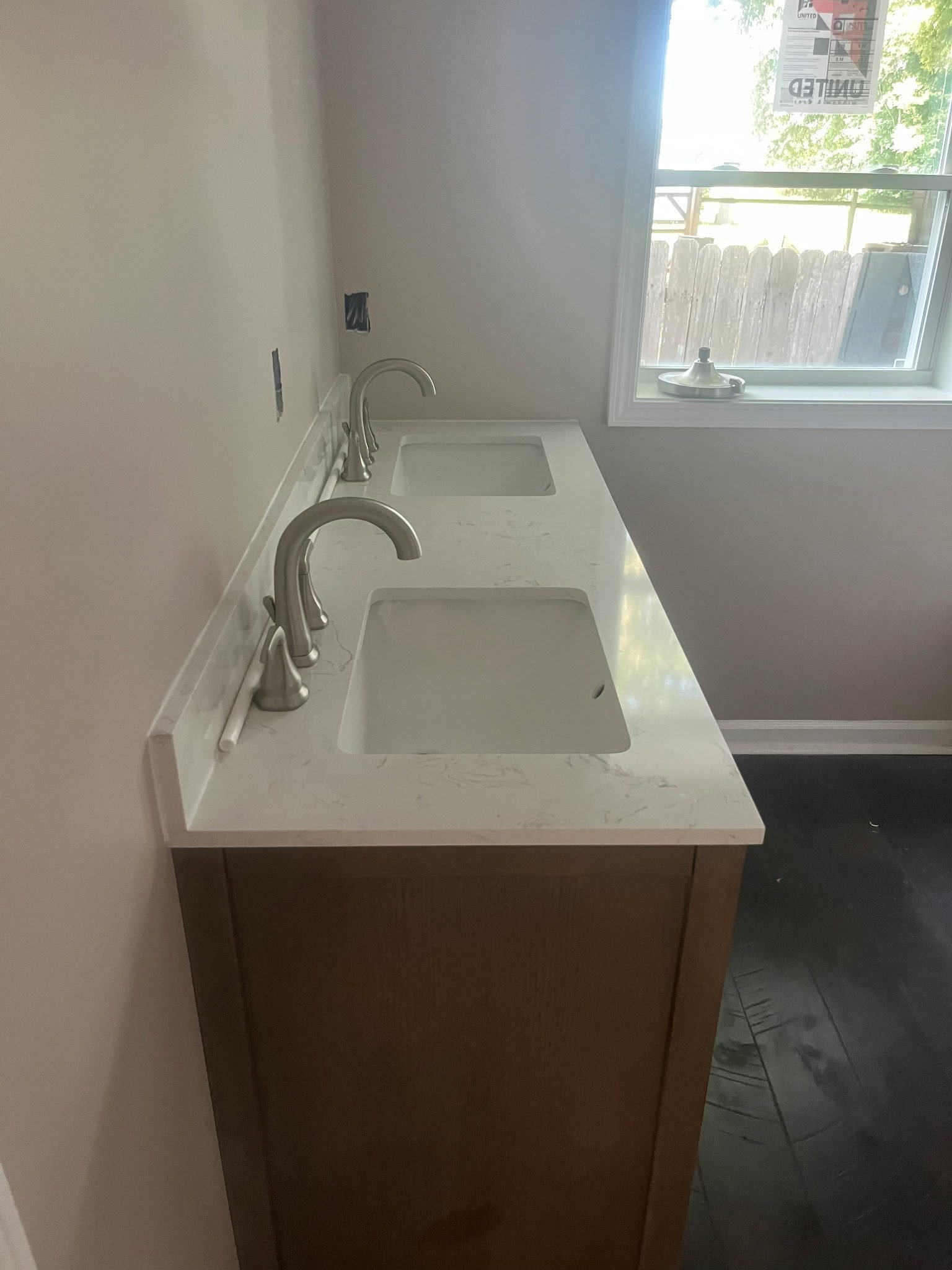White quartz double-sink bathroom vanity with brushed nickel faucets newly installed.