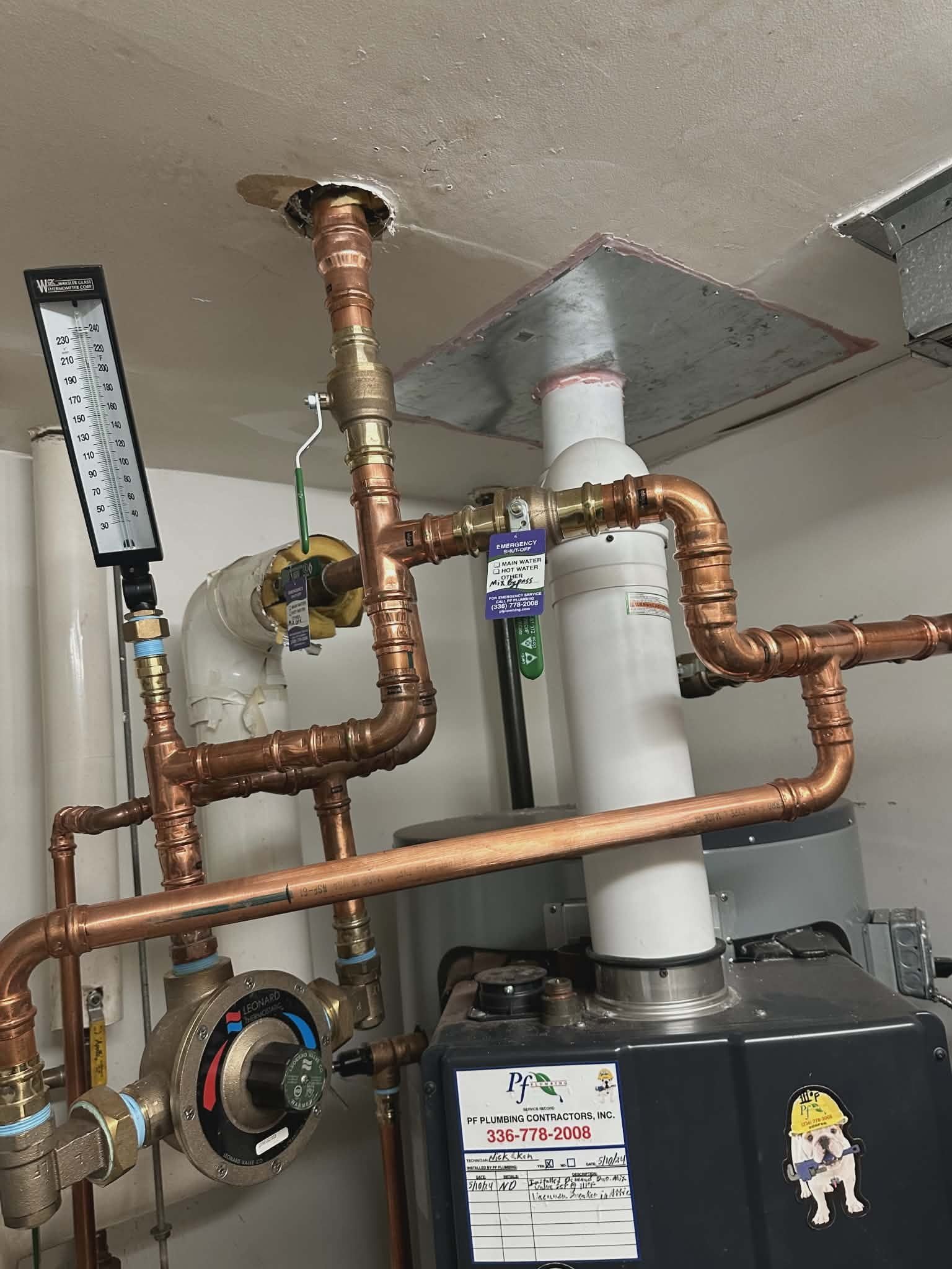 Overhead copper piping with a temperature gauge and pressure regulator near the ceiling.