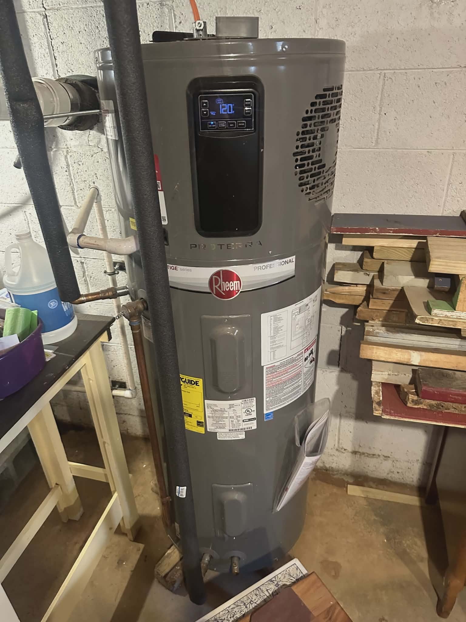 Garbage disposal unit and PVC P-trap piping installed under a kitchen sink.