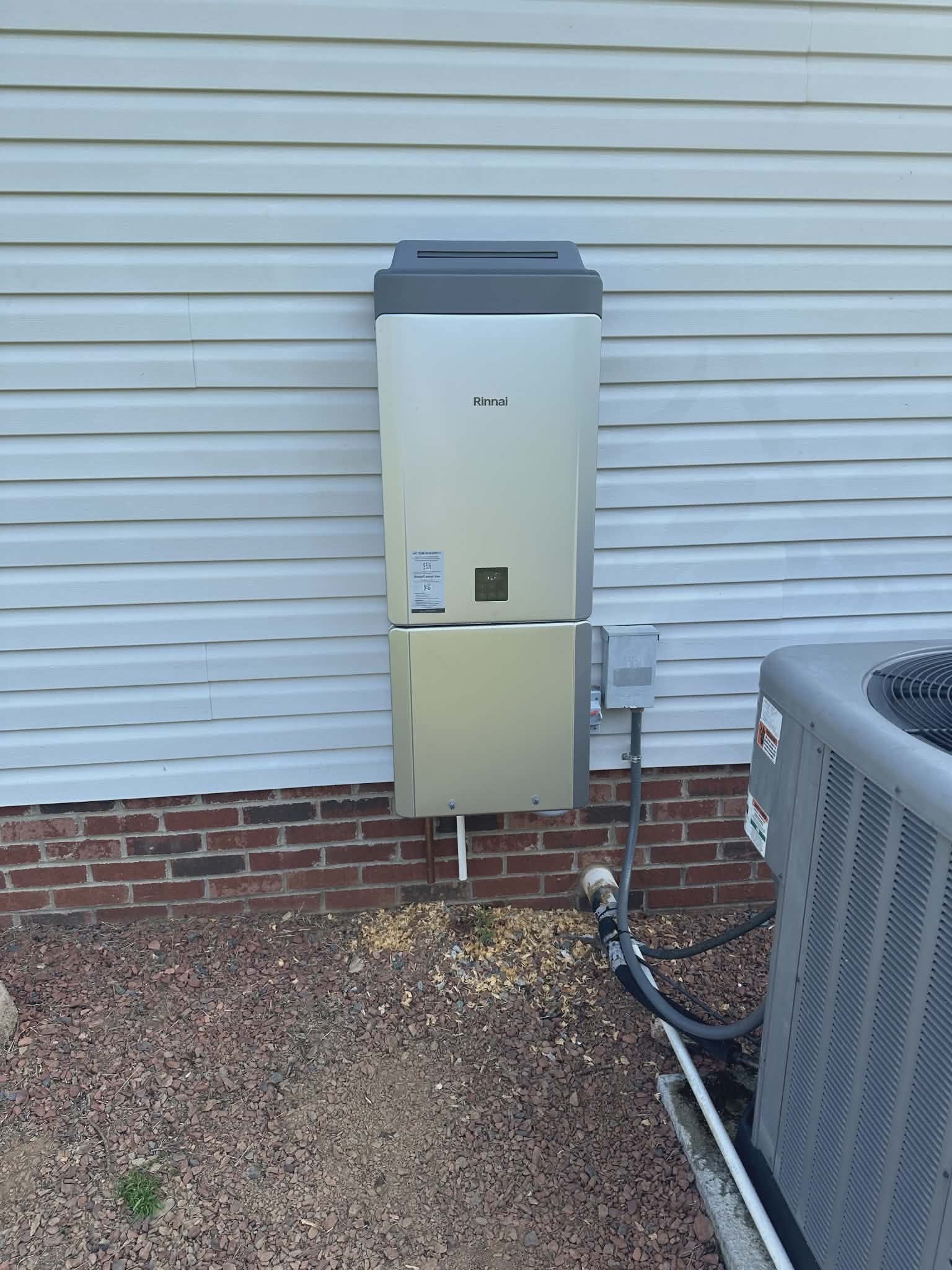 Gas water heater with two PVC vent pipes installed in a basement utility area.