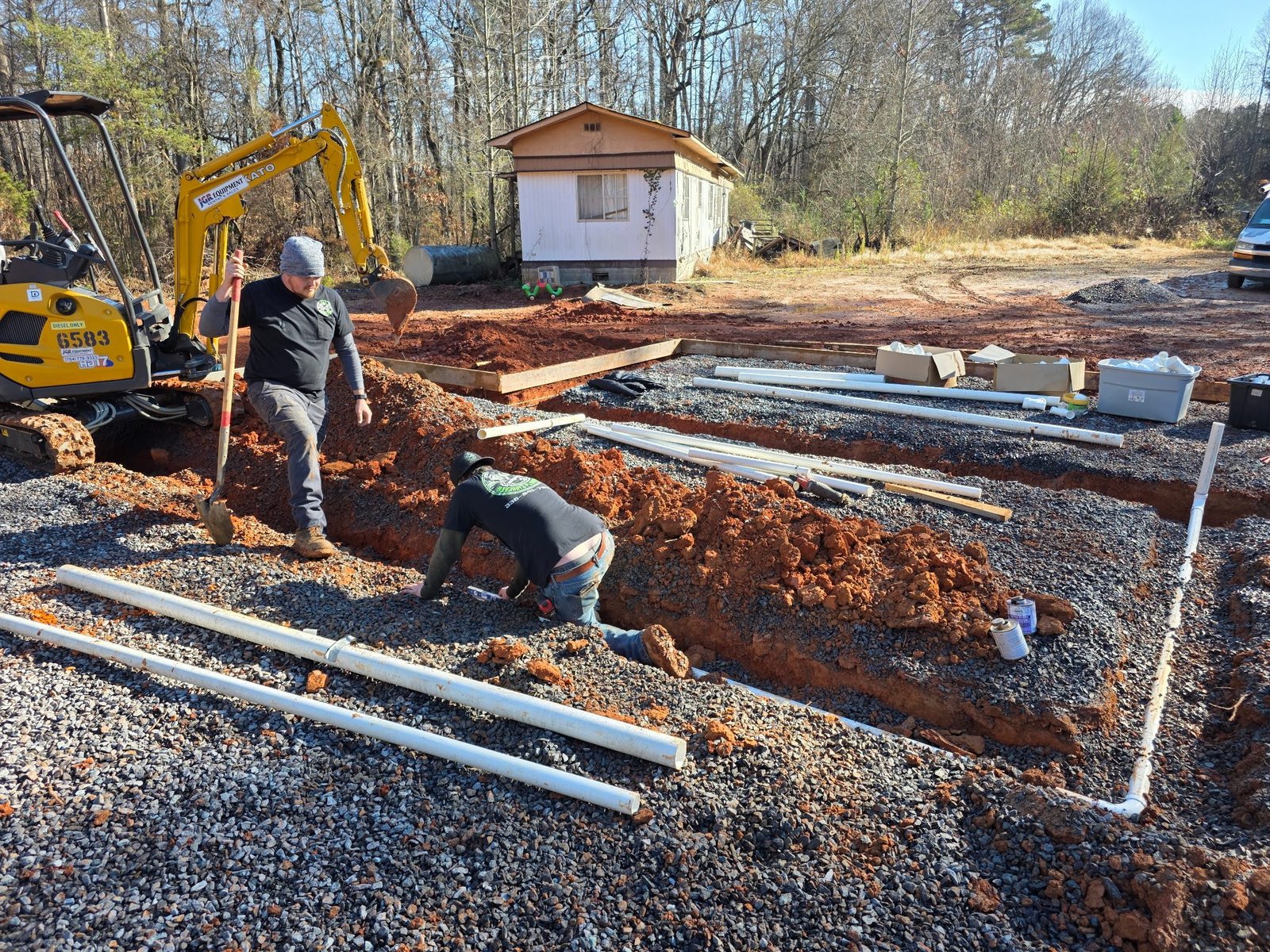 Burcham's Plumbing crew installing underground pipe on a new construction job site