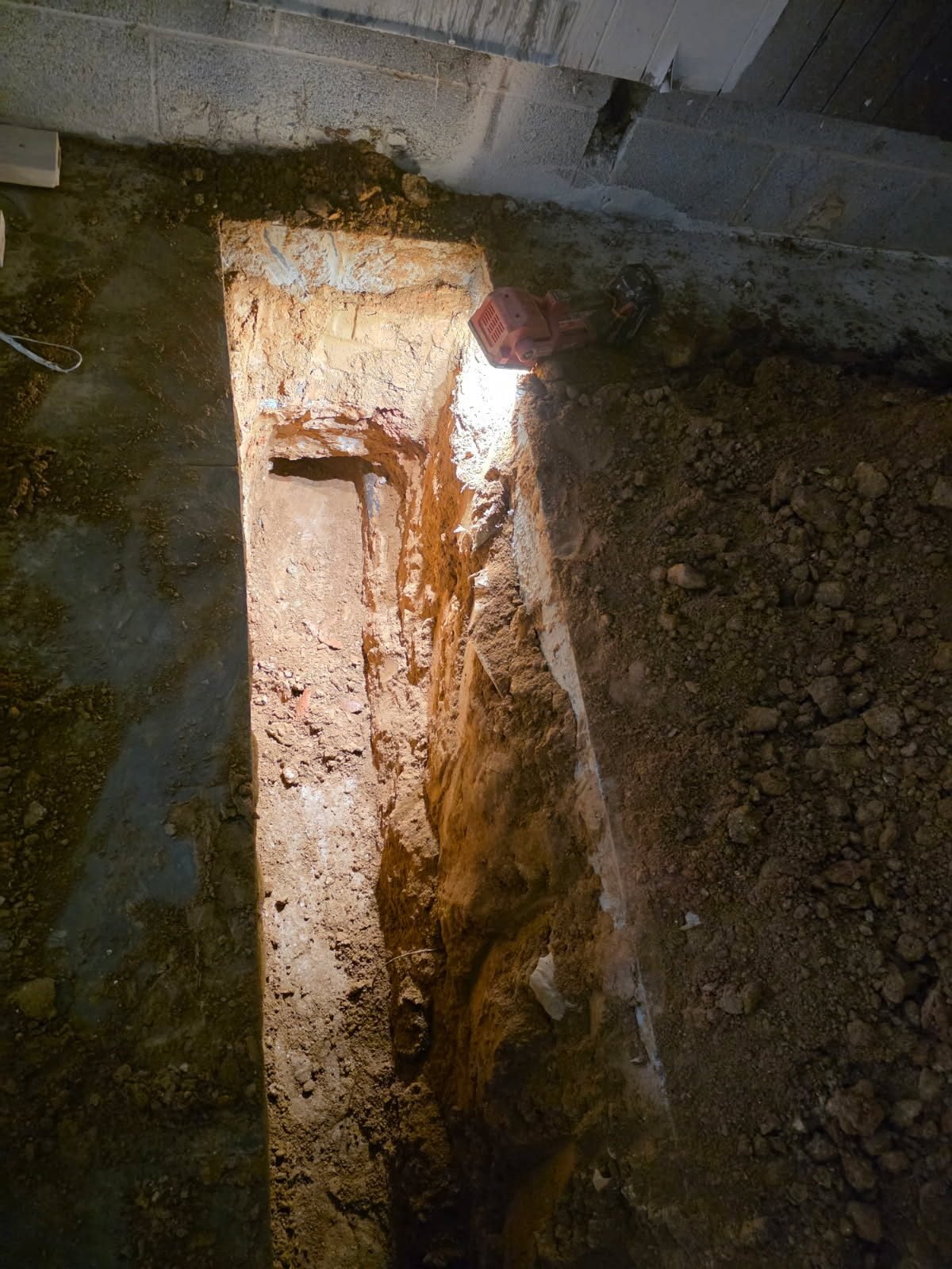 Close-up of a trench cut through a concrete slab edge with exposed soil.